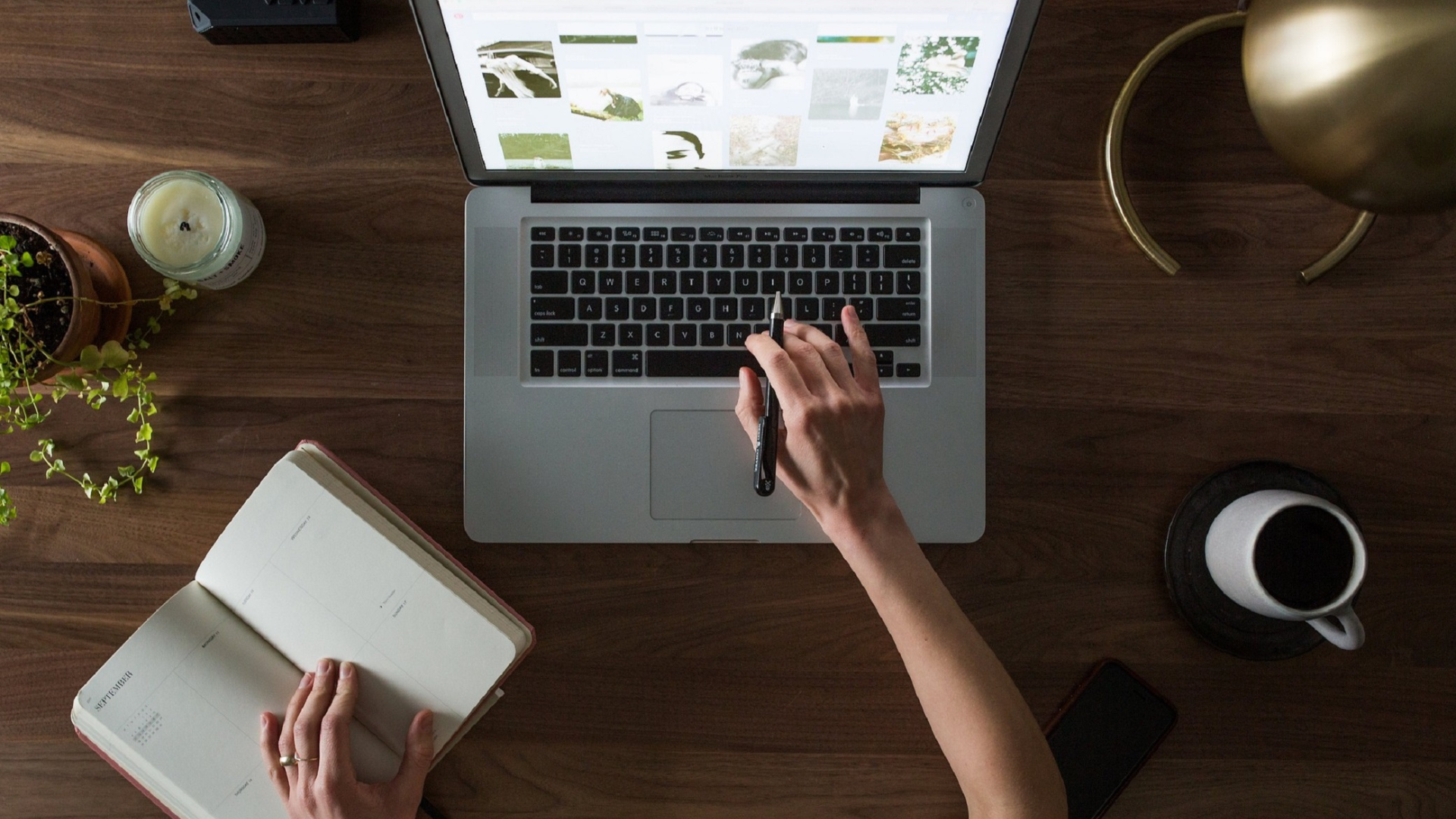 hands typing on a laptop while check notes from a book