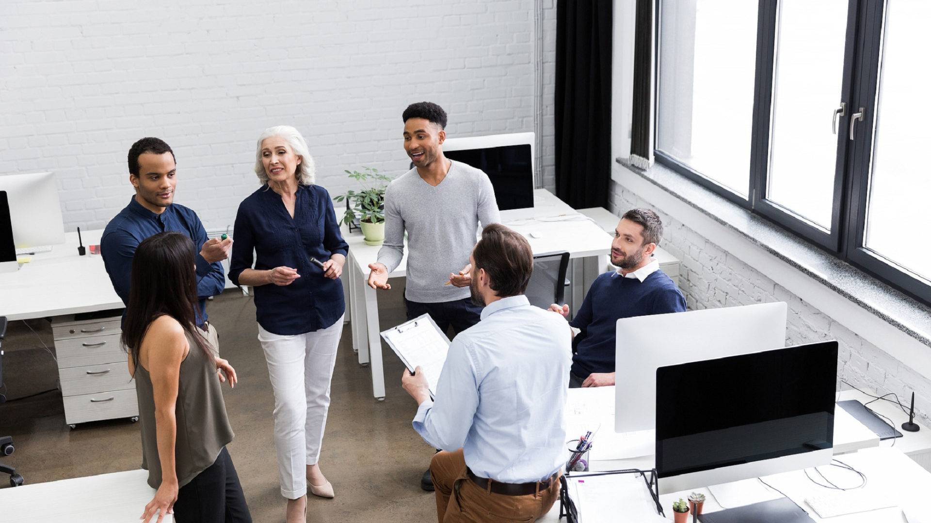 people in a standing team meeting
